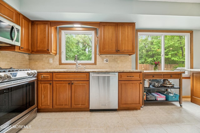 325 Oak Hill Rd, Red Bank, NJ 07701 - kitchen featuring appliances with stainless steel finishes, a sink, brown cabinetry, and healthy amount of natural light