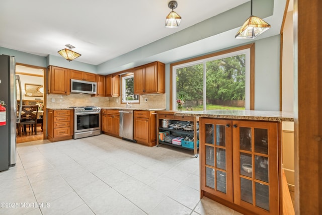 325 Oak Hill Rd, Red Bank, NJ 07701 - kitchen featuring stainless steel appliances, tasteful backsplash, brown cabinets, and light stone countertops