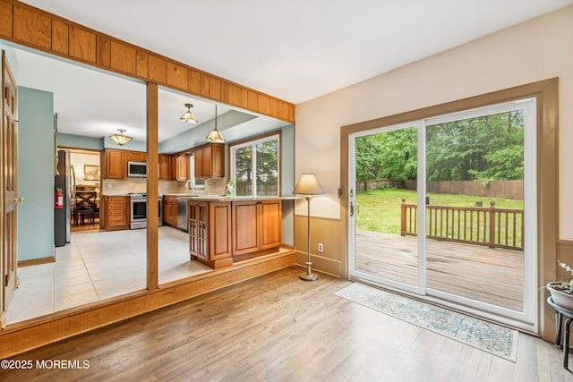 325 Oak Hill Rd, Red Bank, NJ 07701 - kitchen with appliances with stainless steel finishes, brown cabinetry, light countertops, tasteful backsplash, and light wood-type flooring