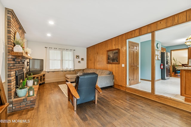 325 Oak Hill Rd, Red Bank, NJ 07701 - living room with wood walls, light wood-style flooring, a fireplace, and baseboards