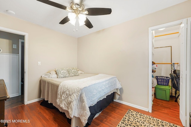 bedroom featuring wood finished floors, baseboards, and a ceiling fan