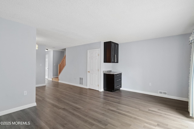 21 Steeple Chase Ct, Tinton Falls, NJ 07724 - unfurnished living room with stairs, dark wood-style flooring, baseboards, and a textured ceiling