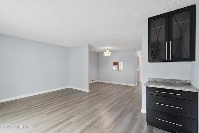 21 Steeple Chase Ct, Tinton Falls, NJ 07724 - unfurnished living room with light wood-style floors, a textured ceiling, and baseboards