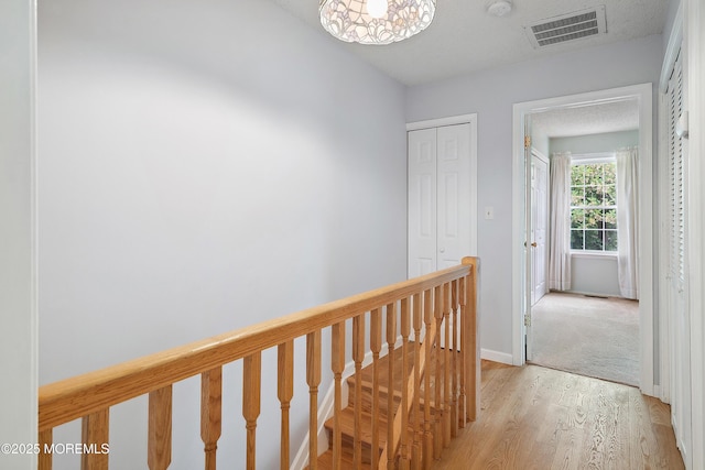 21 Steeple Chase Ct, Tinton Falls, NJ 07724 - hallway with an upstairs landing, light wood finished floors, and baseboards