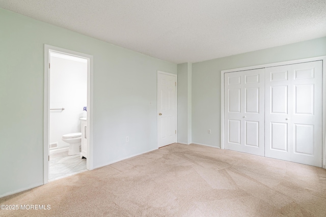 21 Steeple Chase Ct, Tinton Falls, NJ 07724 - unfurnished bedroom featuring carpet, a closet, ensuite bathroom, and a textured ceiling