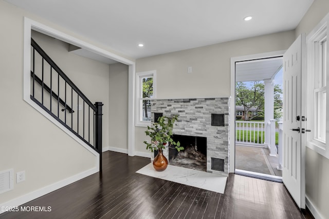 unfurnished living room featuring wood finished floors, a fireplace with flush hearth, stairs, recessed lighting, and baseboards