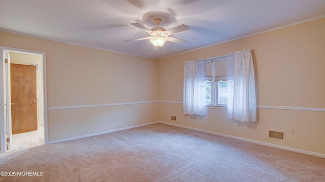 empty room with ceiling fan, carpet flooring, baseboards, and crown molding