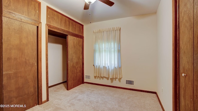 unfurnished bedroom with light colored carpet, baseboards, and a ceiling fan