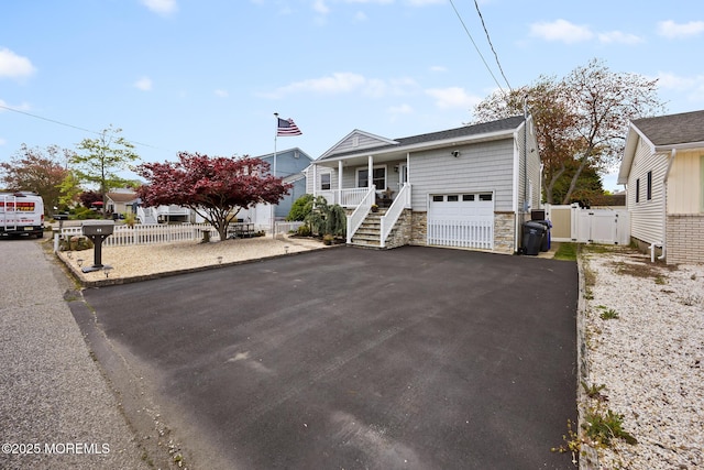 44 Cabana Dr, Brick, NJ 08723 - view of front of house with stone siding, covered porch, asphalt driveway, a gate, and stairs