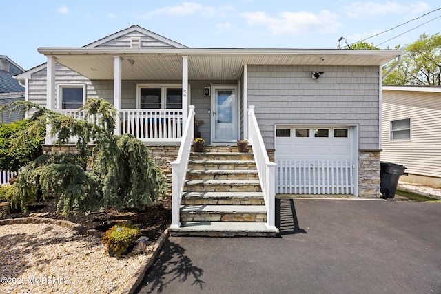 44 Cabana Dr, Brick, NJ 08723 - view of front facade with a garage, covered porch, driveway, and stone siding