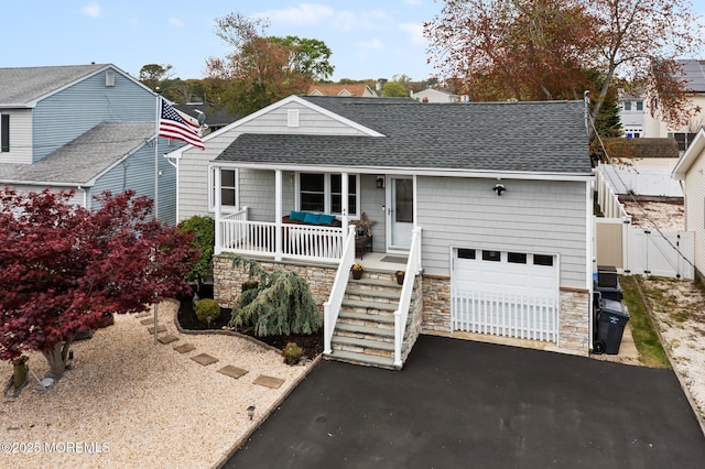 44 Cabana Dr, Brick, NJ 08723 - ranch-style home with a porch, stone siding, roof with shingles, driveway, and fence