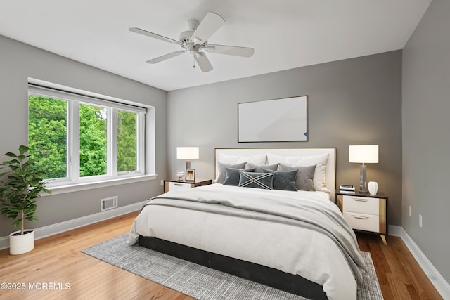 bedroom featuring wood finished floors, baseboards, and ceiling fan