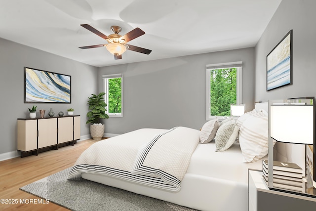 bedroom with light wood finished floors, baseboards, and a ceiling fan