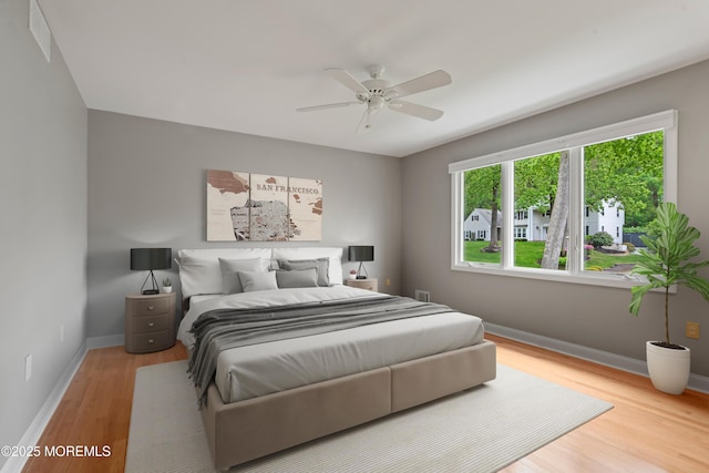 bedroom featuring wood finished floors, baseboards, and ceiling fan
