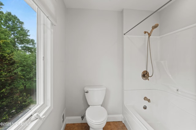 bathroom with baseboards, toilet, shower / bath combination, and tile patterned floors