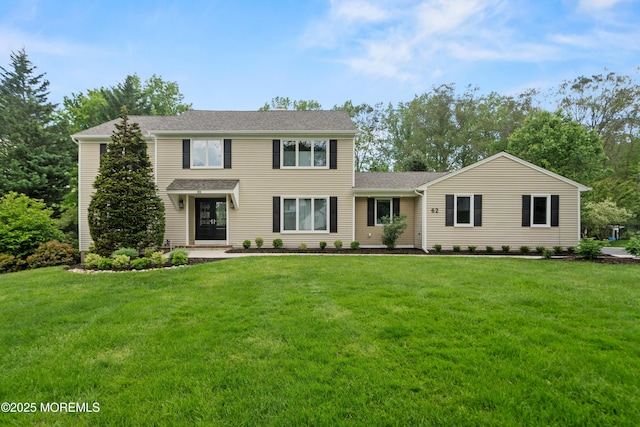 view of front of property with a front yard and roof with shingles