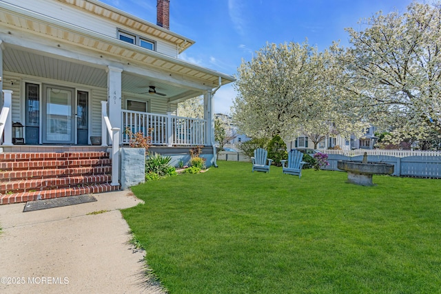 view of yard with a porch and a ceiling fan