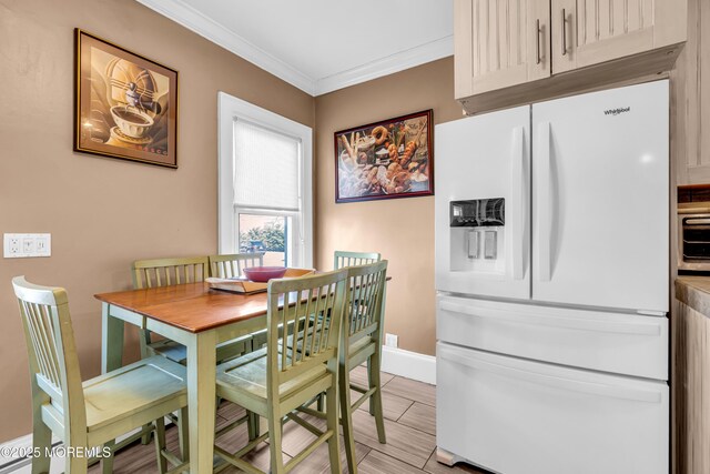 dining space with crown molding and baseboards