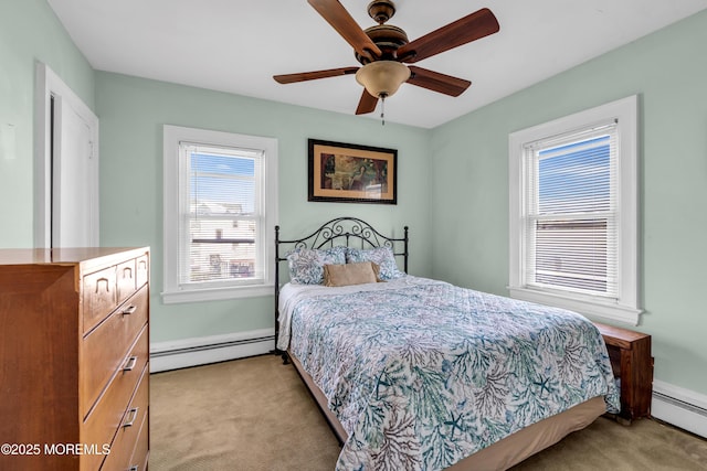 bedroom featuring baseboard heating, light carpet, and baseboards