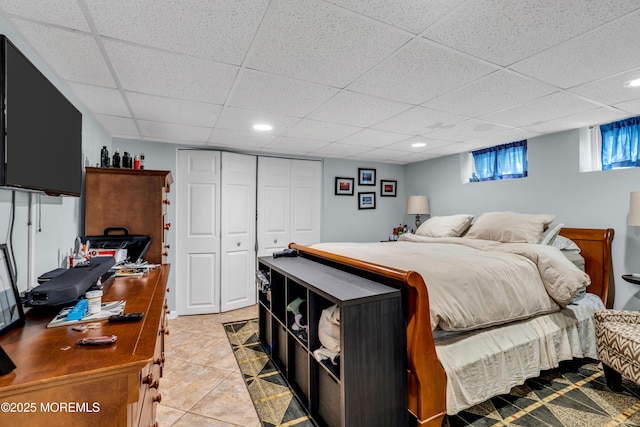 bedroom featuring a closet, a paneled ceiling, light tile patterned floors, and recessed lighting