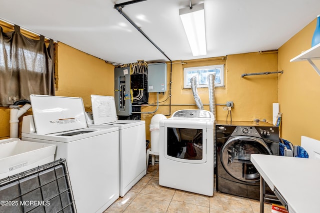 clothes washing area featuring independent washer and dryer, electric panel, light tile patterned floors, and a sink