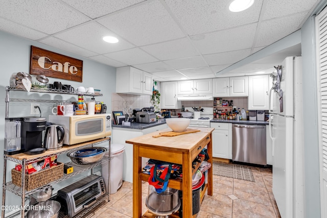 kitchen with white appliances, white cabinets, decorative backsplash, a drop ceiling, and recessed lighting