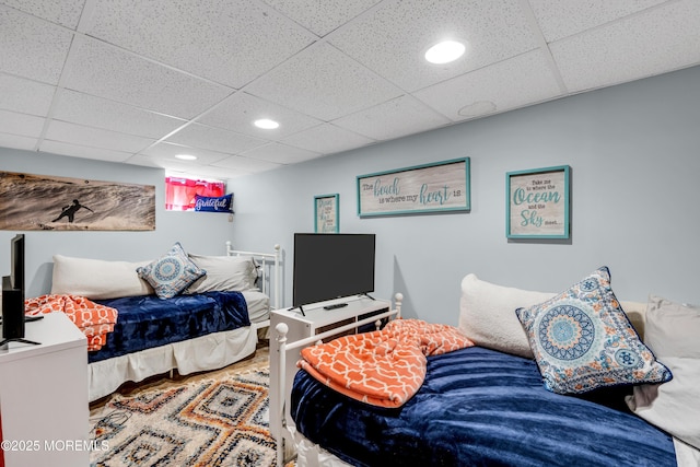 bedroom with a paneled ceiling, recessed lighting, and wood finished floors