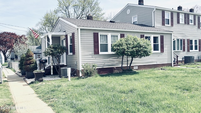 view of side of property with a chimney, a yard, central AC, and crawl space