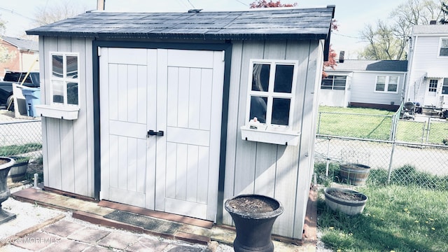 view of shed featuring fence