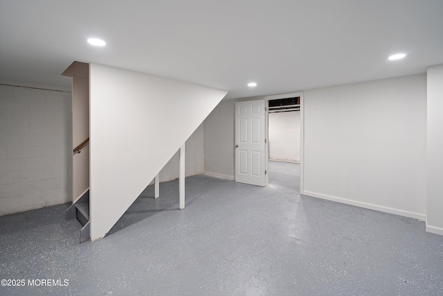finished below grade area with recessed lighting, concrete block wall, and stairway
