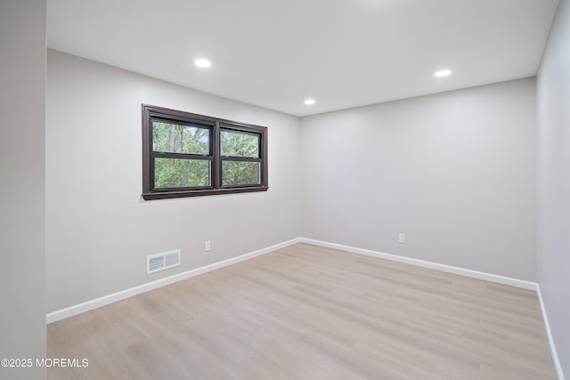 unfurnished room with light wood finished floors, baseboards, and recessed lighting