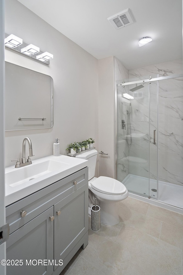 full bath with toilet, vanity, and a marble finish shower