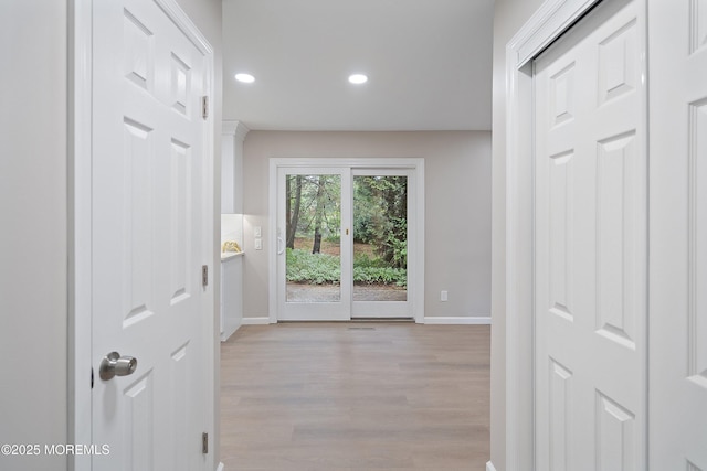 hall with baseboards, light wood-type flooring, and recessed lighting