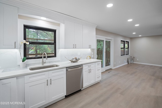kitchen featuring a sink, stainless steel dishwasher, recessed lighting, white cabinetry, and light wood-style flooring