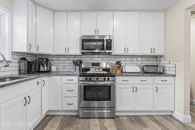 307 Seminole Trl, Browns Mills, NJ 08015 - kitchen featuring stainless steel appliances, a sink, dark stone countertops, and backsplash