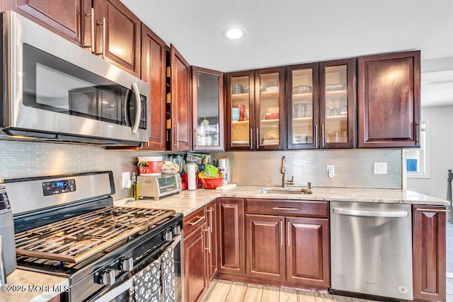 243 6th Ave, Long Branch, NJ 07740 - kitchen with appliances with stainless steel finishes, light stone countertops, backsplash, glass insert cabinets, and recessed lighting
