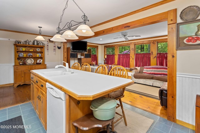 19 Kenyon Dr, Plumsted, NJ 08533 - kitchen with white dishwasher, a sink, a wainscoted wall, an island with sink, and open shelves