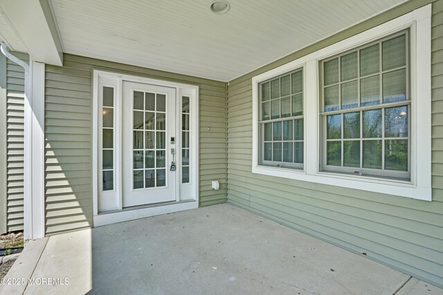 view of exterior entry featuring covered porch