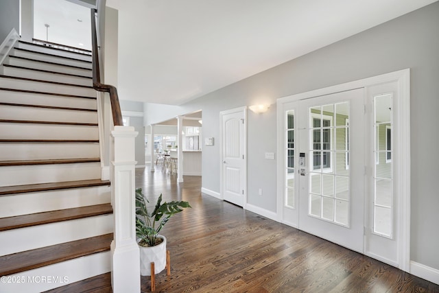 entryway featuring stairway, wood finished floors, and baseboards