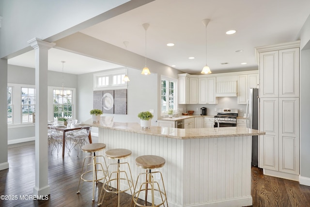 kitchen featuring stainless steel appliances, light stone counters, dark wood-style flooring, baseboards, and recessed lighting