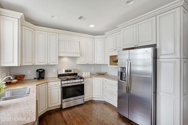 kitchen featuring stainless steel appliances, a sink, custom exhaust hood, dark wood finished floors, and light stone countertops