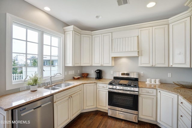 kitchen with stainless steel appliances, a sink, plenty of natural light, recessed lighting, and light stone counters