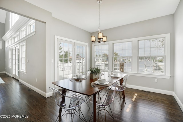 dining area featuring a chandelier, baseboards, and dark wood-style floors