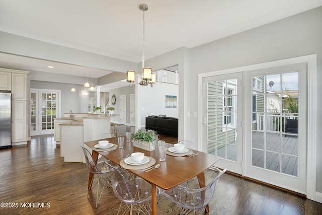 dining space featuring a chandelier, plenty of natural light, and dark wood-type flooring