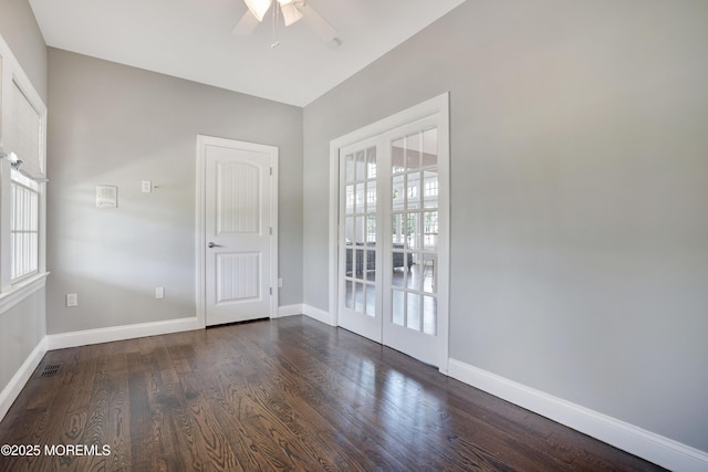 spare room featuring a ceiling fan, baseboards, and dark wood-style floors