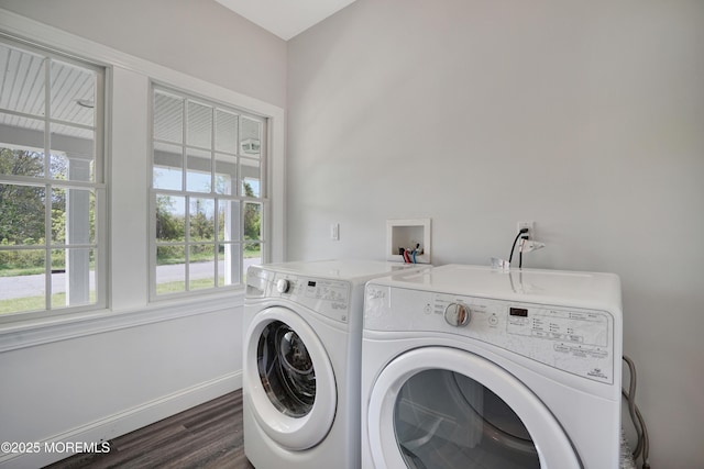washroom featuring washing machine and dryer, dark wood-type flooring, and baseboards