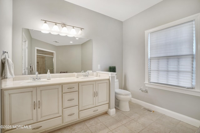 full bathroom with a shower stall, toilet, baseboards, double vanity, and tile patterned floors