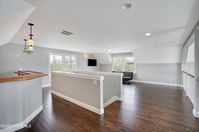 kitchen featuring open floor plan, baseboards, dark wood finished floors, lofted ceiling, and hanging light fixtures
