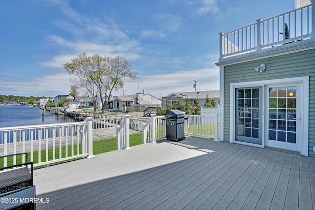 deck featuring area for grilling, a water view, a lawn, and a residential view