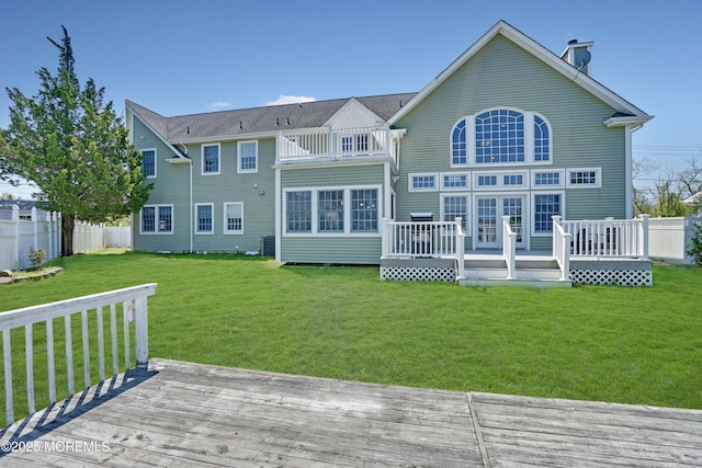 back of house featuring a balcony and a wooden deck